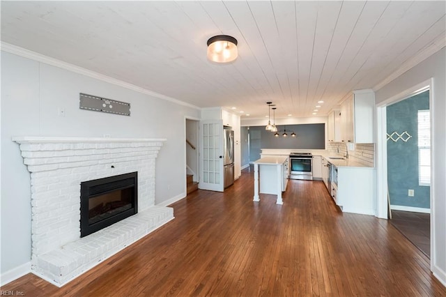 kitchen with hanging light fixtures, a center island, stainless steel appliances, decorative backsplash, and white cabinets