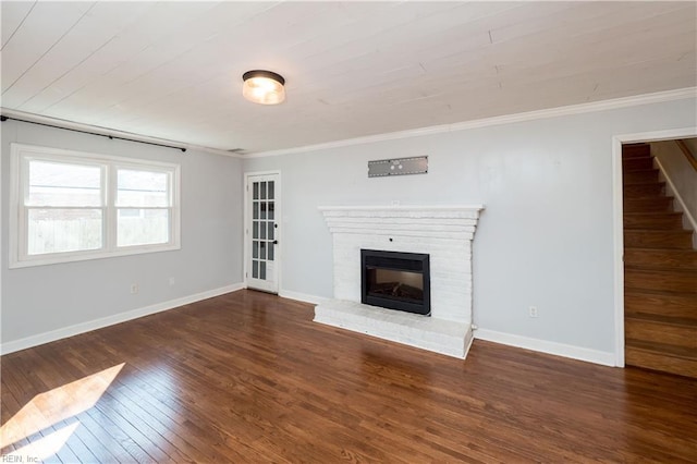 unfurnished living room featuring dark hardwood / wood-style floors, wooden ceiling, crown molding, and a fireplace