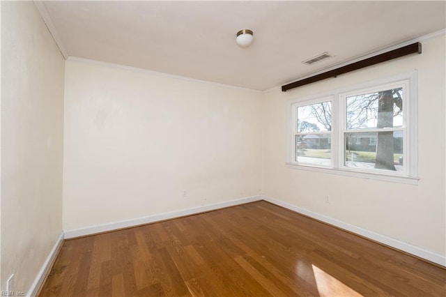 empty room with hardwood / wood-style floors and ornamental molding