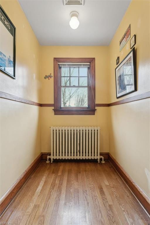 unfurnished room with light wood-type flooring and radiator heating unit