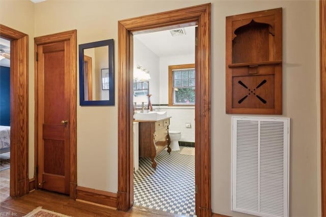 hall with tile walls and sink