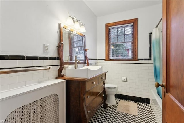 full bathroom featuring tile walls, shower / bath combo, vanity, and toilet