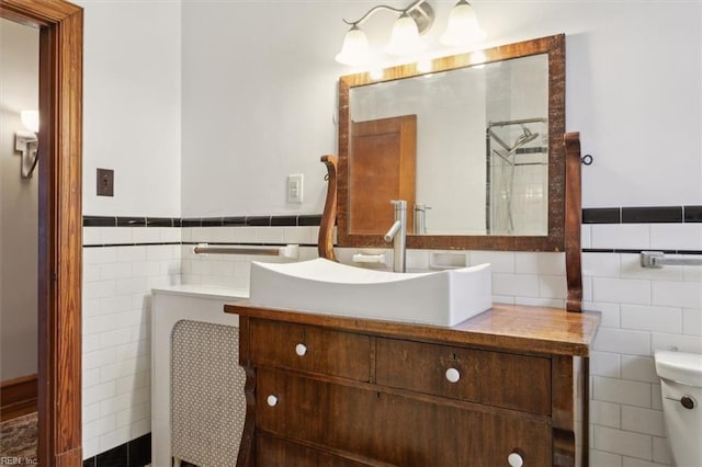 bathroom with toilet, vanity, and tile walls