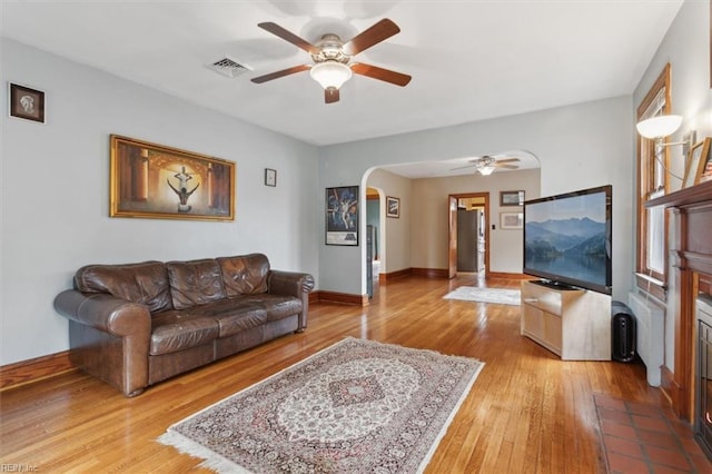 living room featuring ceiling fan and hardwood / wood-style flooring