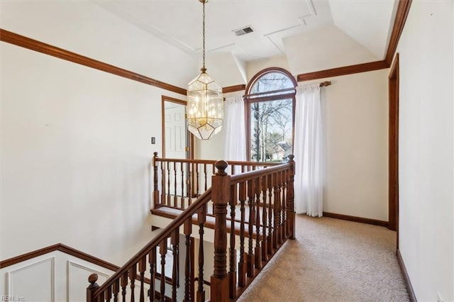 hall featuring carpet flooring and a chandelier