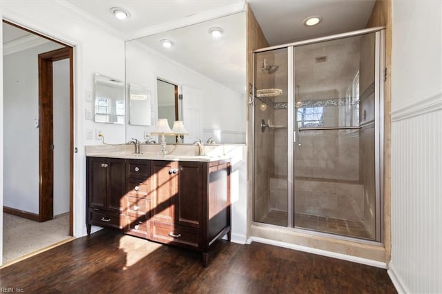 bathroom featuring ornamental molding, walk in shower, wood-type flooring, and vanity