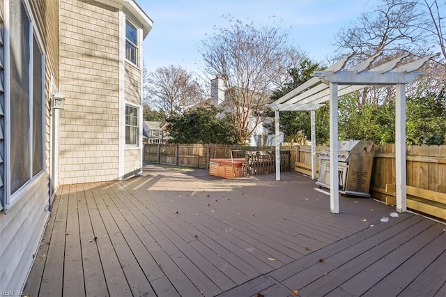 wooden deck with a hot tub, a pergola, and area for grilling