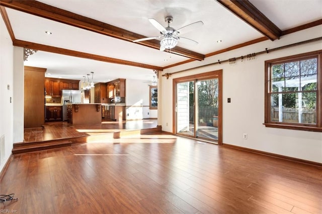 unfurnished living room with ceiling fan, beam ceiling, dark hardwood / wood-style floors, and crown molding