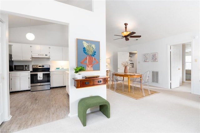 kitchen with stainless steel appliances, white cabinets, ceiling fan, hanging light fixtures, and light colored carpet