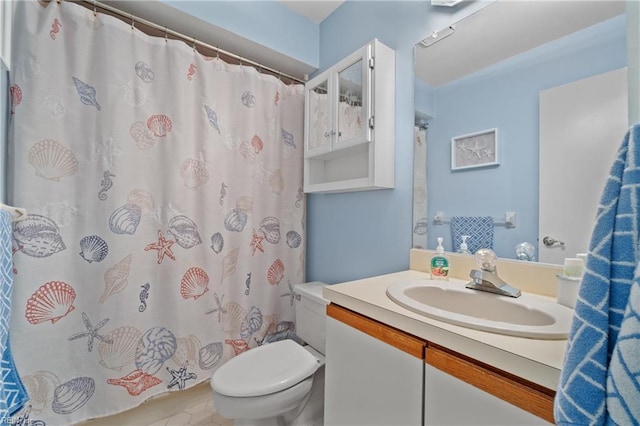 bathroom with curtained shower, toilet, and vanity