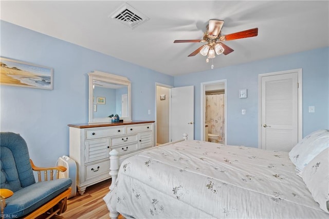 bedroom with ceiling fan, light hardwood / wood-style floors, and connected bathroom