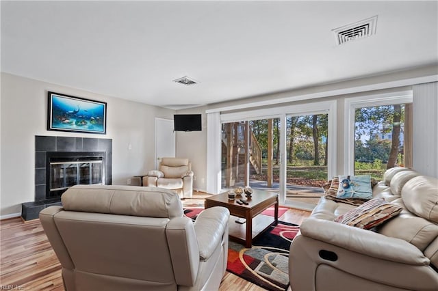 living room featuring light hardwood / wood-style floors and a tile fireplace