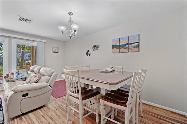 dining room featuring light hardwood / wood-style floors and a chandelier