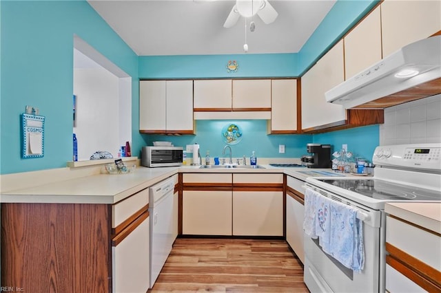 kitchen with white cabinetry, sink, and white appliances