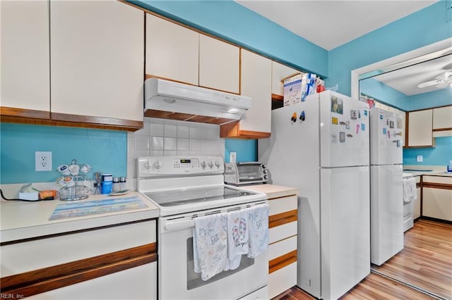 kitchen with tasteful backsplash, white cabinets, white appliances, and light hardwood / wood-style floors