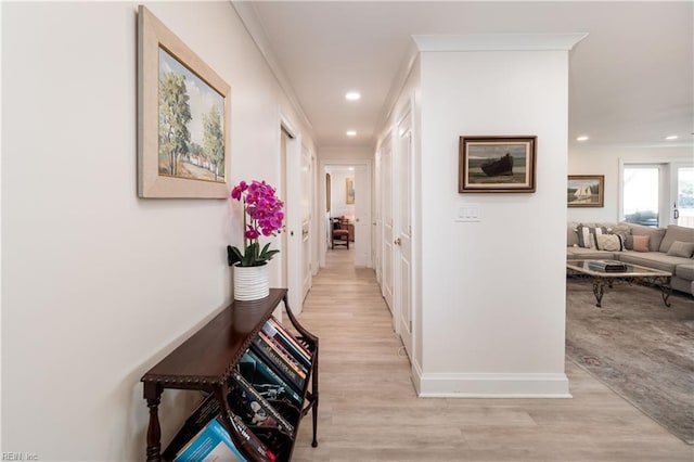 hall with light hardwood / wood-style flooring and ornamental molding