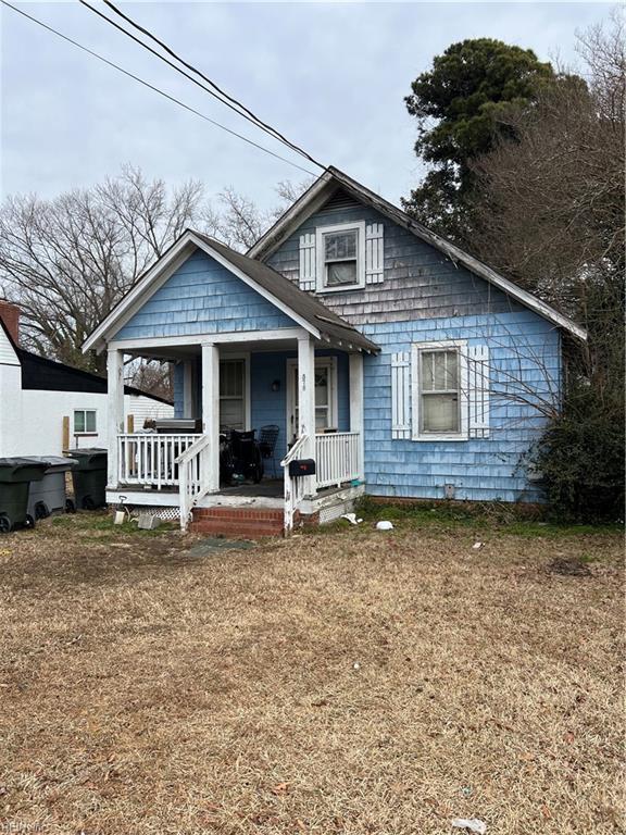 bungalow featuring covered porch and a front lawn