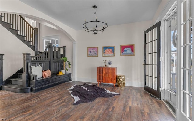 entryway with french doors, dark hardwood / wood-style floors, and an inviting chandelier