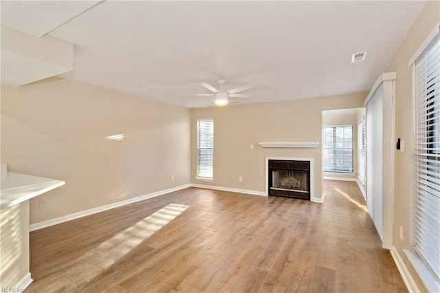 unfurnished living room featuring ceiling fan and light hardwood / wood-style flooring