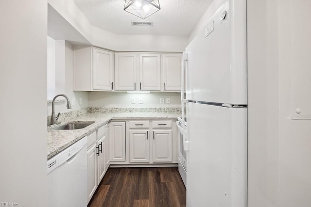 kitchen featuring sink, white appliances, white cabinetry, dark wood-type flooring, and light stone counters