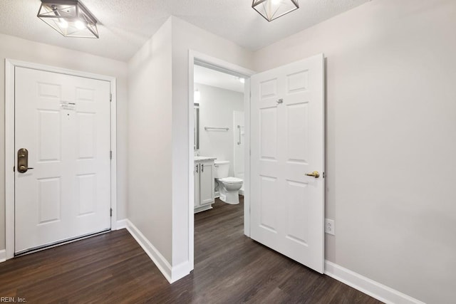 entryway featuring dark wood-type flooring and a textured ceiling