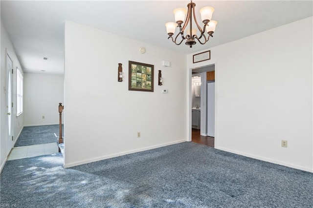 carpeted empty room with a notable chandelier