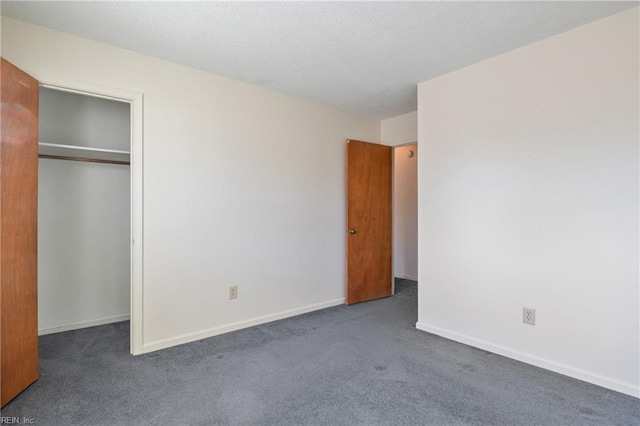 unfurnished bedroom featuring a closet and dark colored carpet