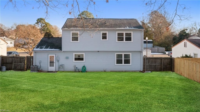 rear view of property featuring a yard and central AC unit