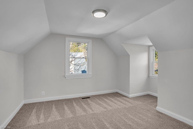 bonus room featuring vaulted ceiling and light colored carpet