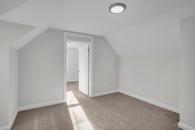 additional living space featuring light carpet and lofted ceiling