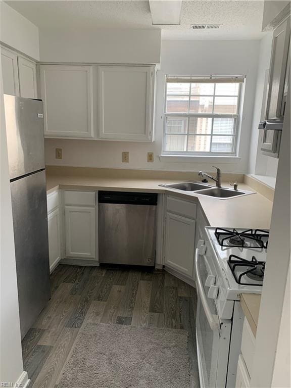 kitchen with sink, white cabinetry, dark hardwood / wood-style floors, and appliances with stainless steel finishes