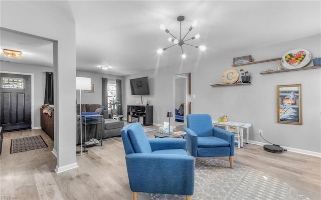 living room featuring a chandelier and light wood-type flooring