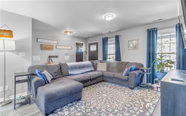 living room with a wealth of natural light and light hardwood / wood-style flooring