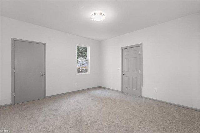 unfurnished room featuring light carpet