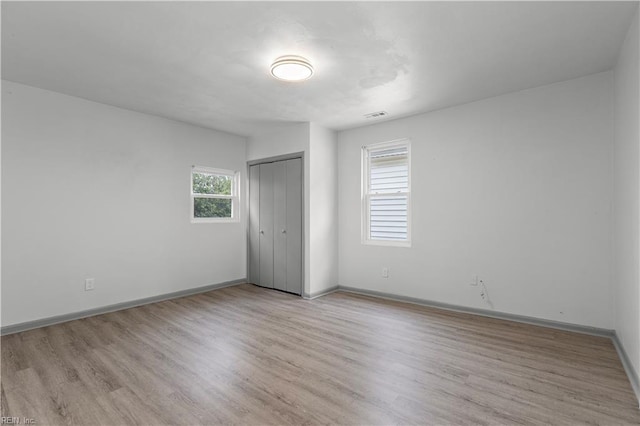 unfurnished bedroom with light hardwood / wood-style floors and a closet