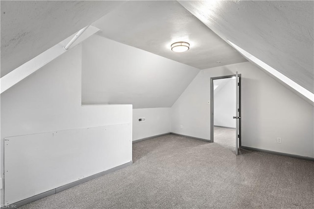 bonus room with vaulted ceiling and carpet