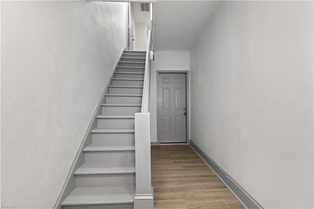 staircase with hardwood / wood-style flooring