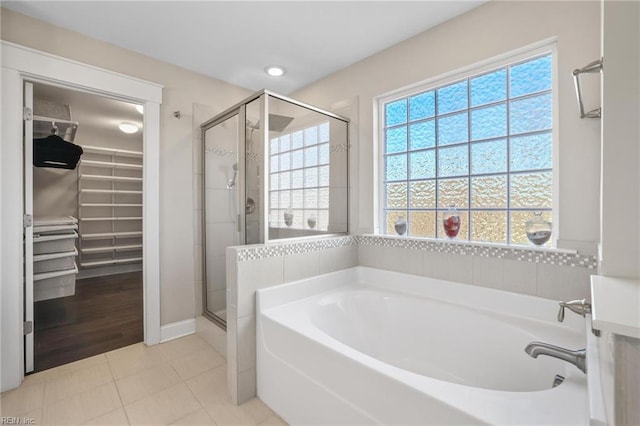 bathroom with separate shower and tub and tile patterned flooring