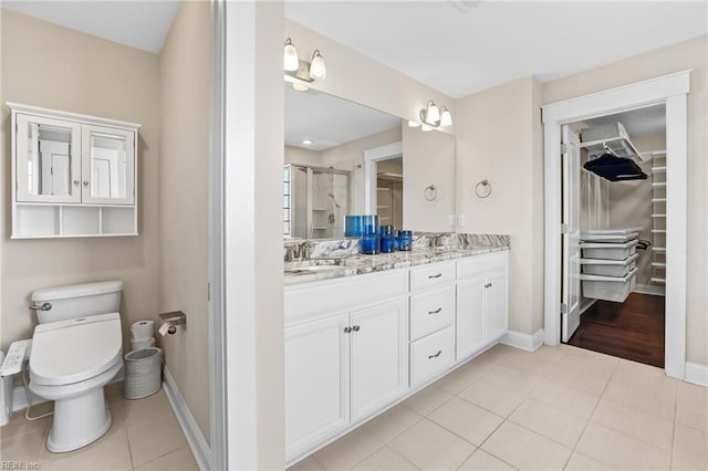 bathroom with toilet, a shower with door, tile patterned flooring, and vanity