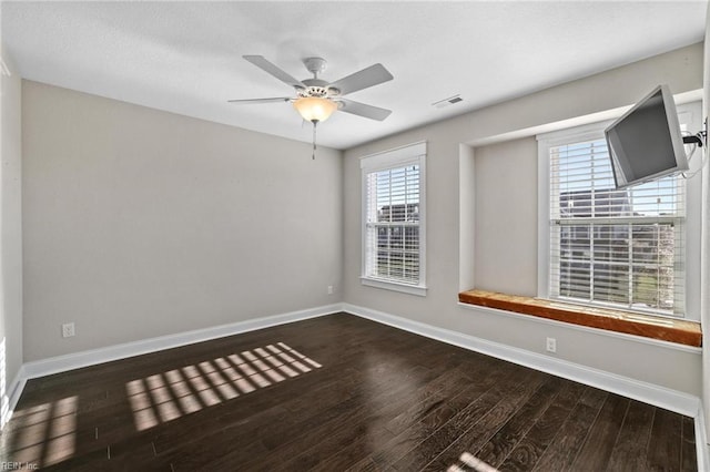 empty room with ceiling fan and dark hardwood / wood-style floors