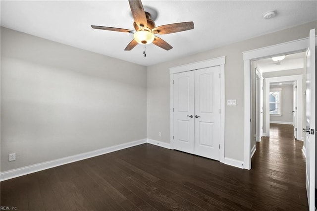 unfurnished bedroom with a closet, ceiling fan, and dark wood-type flooring