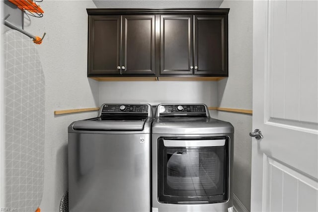 laundry room with washing machine and dryer and cabinets