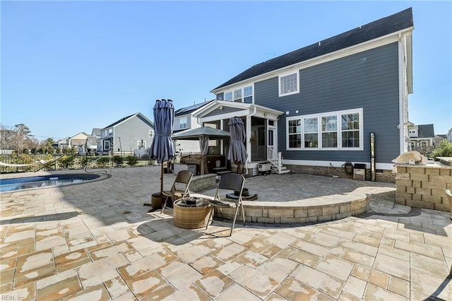 rear view of property with a patio and a sunroom