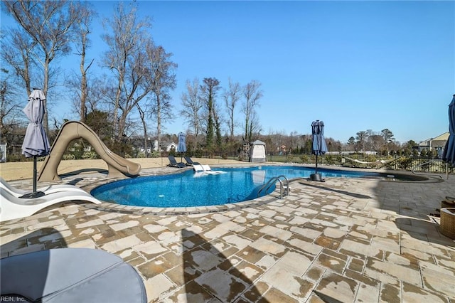 view of pool featuring a water slide and a patio area