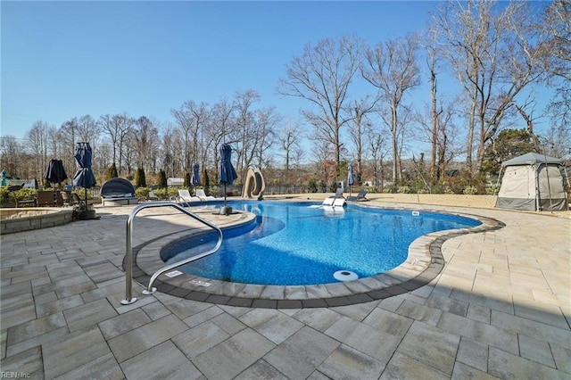 view of pool featuring a water slide and a patio area