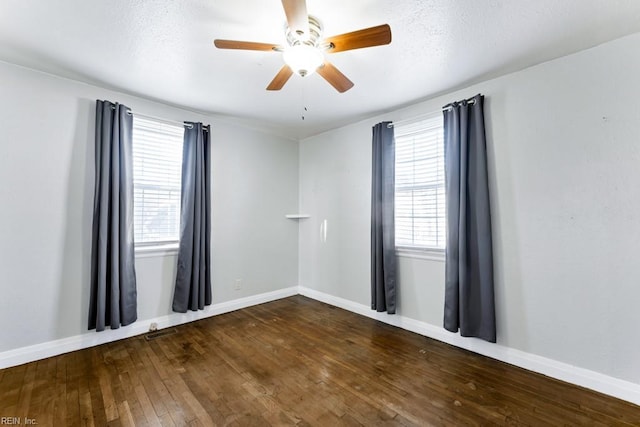 spare room featuring ceiling fan, dark wood-type flooring, and a textured ceiling