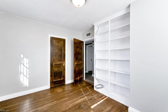 unfurnished bedroom with dark hardwood / wood-style flooring