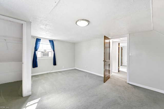 basement featuring a textured ceiling, carpet floors, and cooling unit