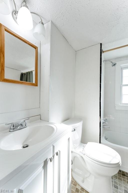 full bathroom featuring a textured ceiling, tiled shower / bath combo, vanity, and toilet