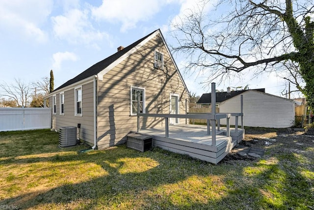 rear view of property featuring a deck, a yard, and central AC unit